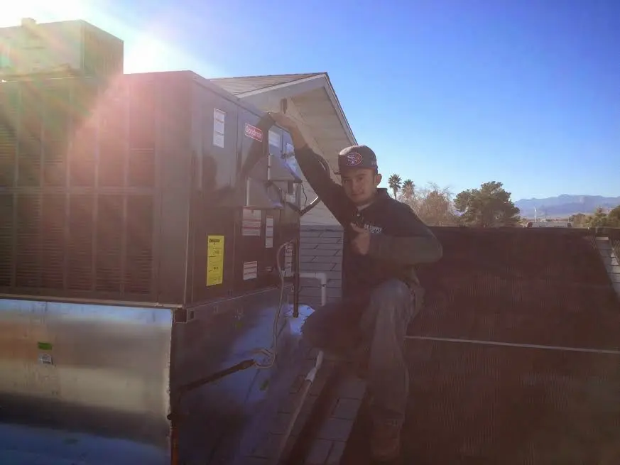 HVAC technician performing HVAC Inspection on a rooftop unit in Akron